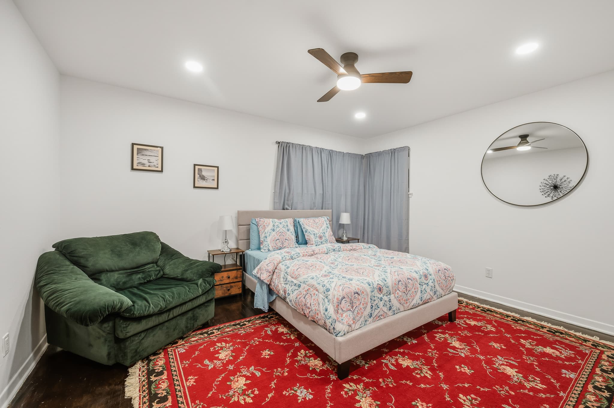Second bedroom with an armchair and a patterned rug